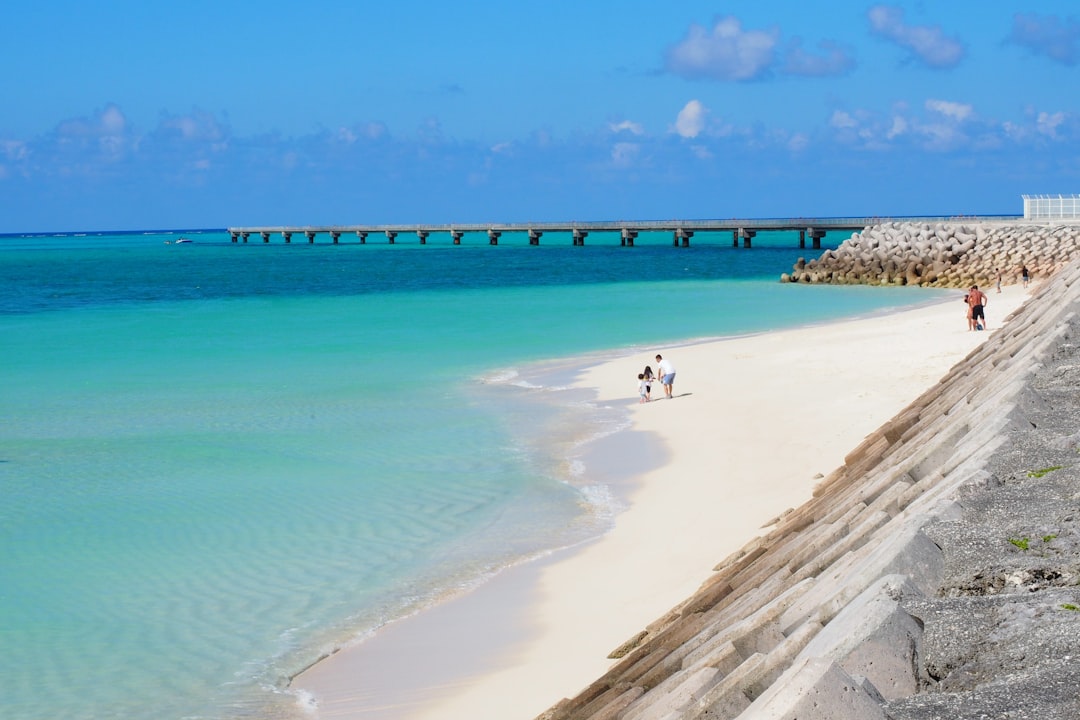 White sand and shallow reef water at Yonaha Maehama Beach on Miyako Island seen from the shoreline on a clear morning