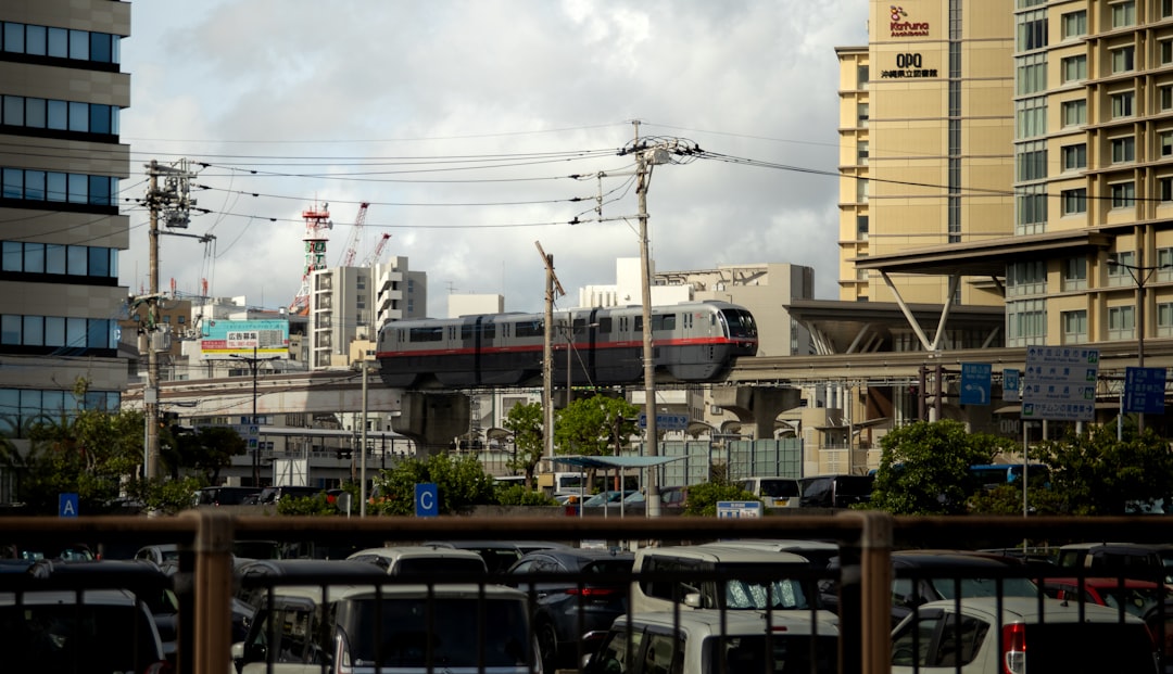 Okinawa Monorail Yui Rail train crossing above a Naha street on a clear weekday morning near Asahibashi