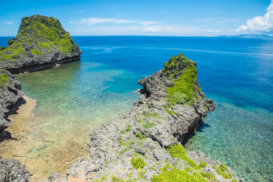 Swimmers and small dive boats above the shallow reef at Cape Maeda in Onna Village on a calm summer morning