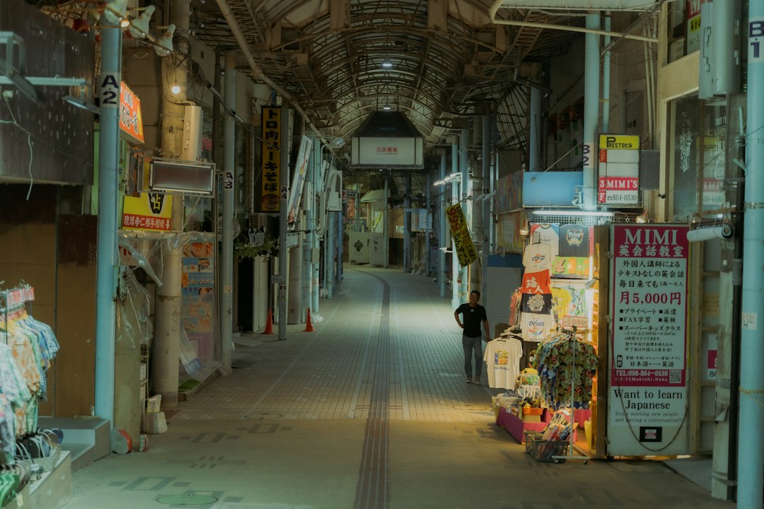 Shoppers under the roofed Heiwa-dori arcade near Makishi Public Market in Naha during heavy afternoon rain